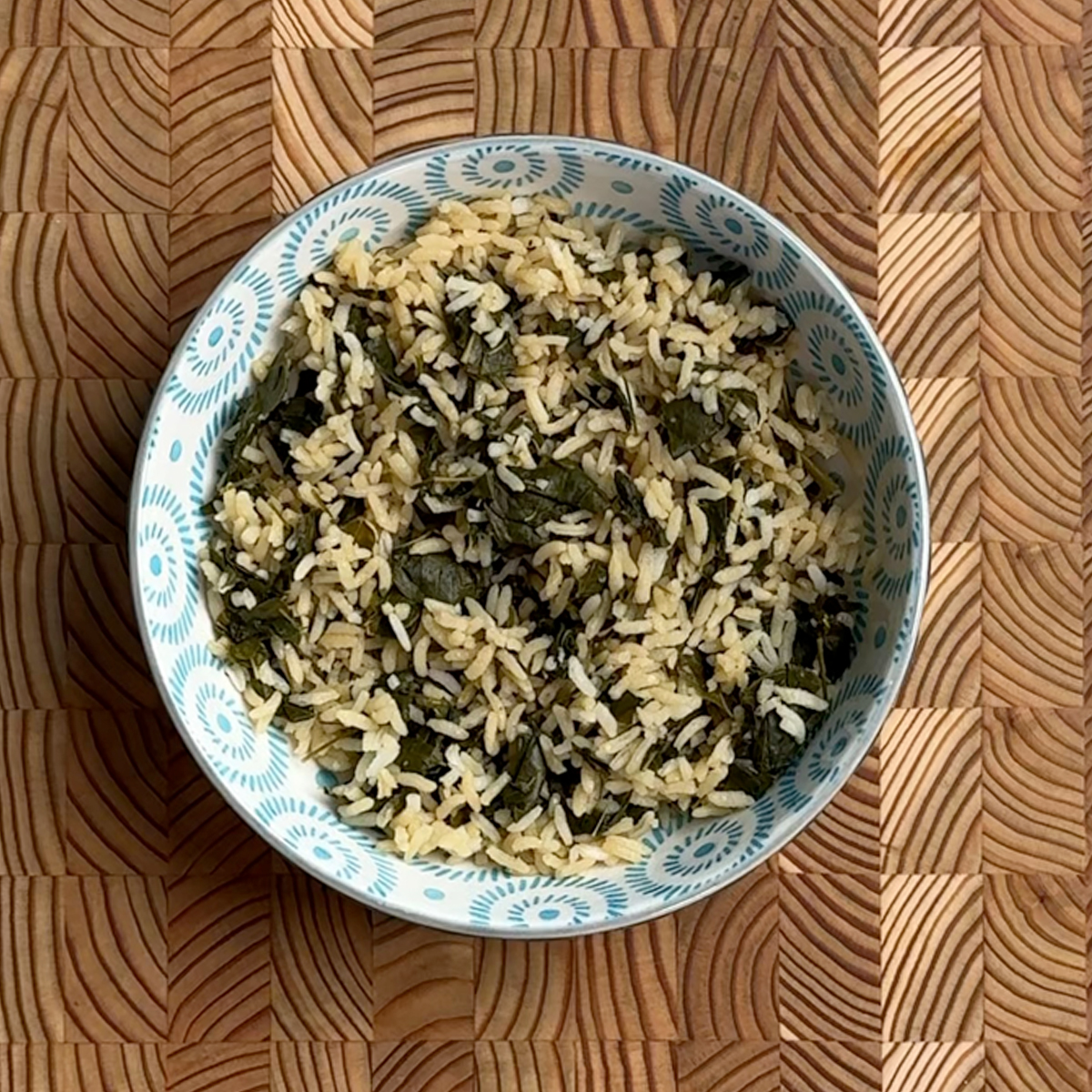 Cooked moringa leaves protein boosted rice with green leaves distributed throughout white rice grains