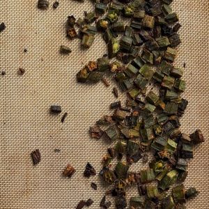 Fully baked crispy okra with golden brown edges spread on a silicone baking mat