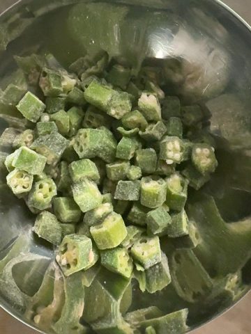 Pre-cut frozen okra ready to cook in a metal bowl
