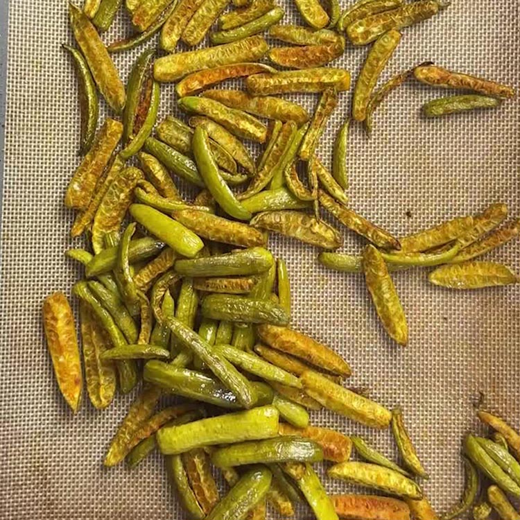 Crispy golden roasted dondakaya on baking sheet after 30 minutes in oven