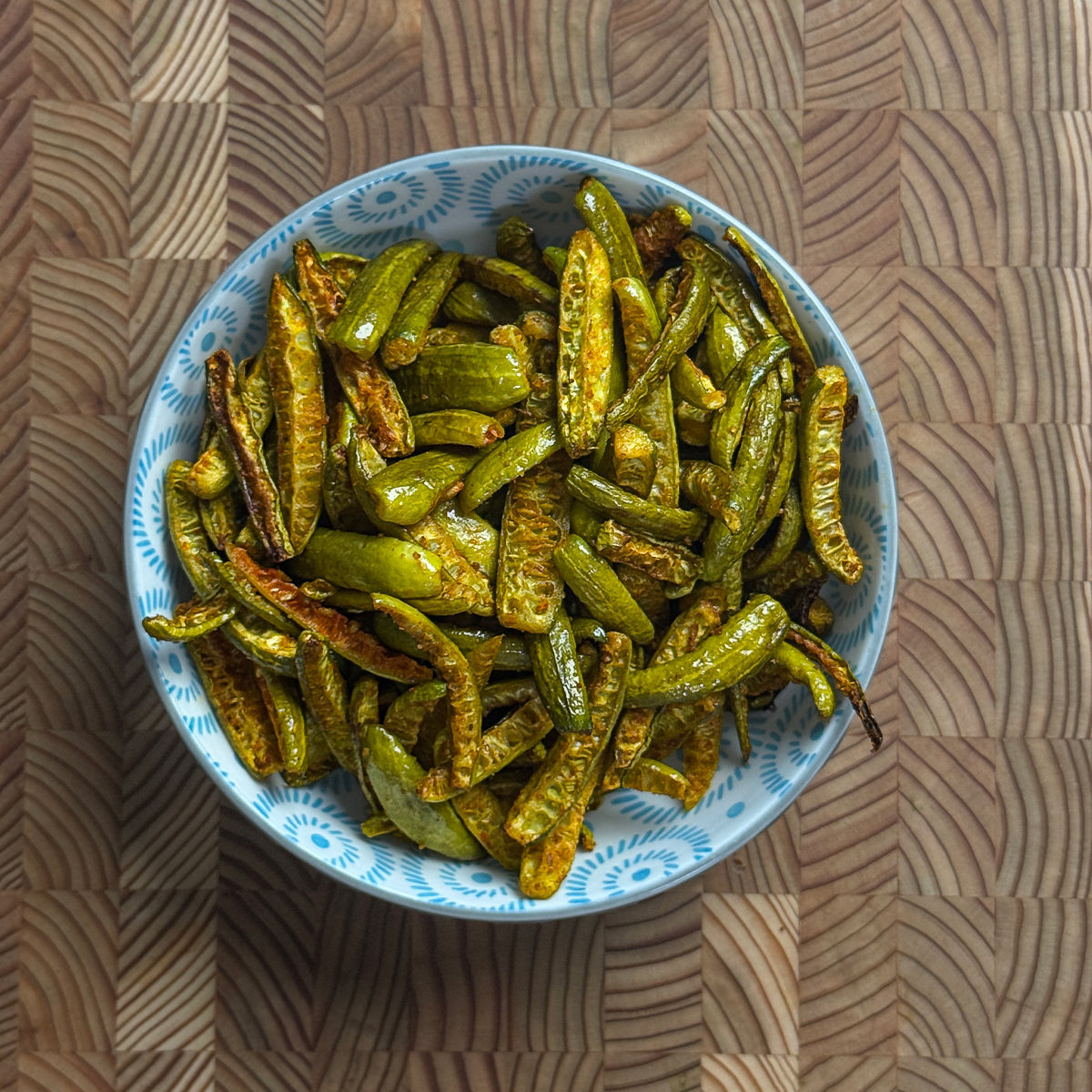 Crispy oven roasted dondakaya fry served in a blue patterned bowl