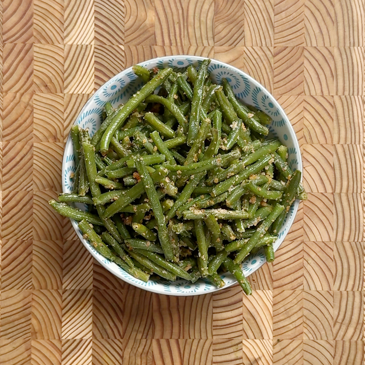 Oven roasted green beans fry with coconut garlic podi served in a blue and white patterned bowl