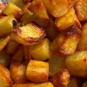 Close up of crispy oven roasted potatoes showing golden brown edges and tender centers