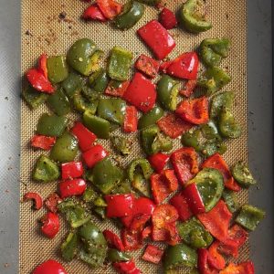 Oven roasted bell peppers on a sheet pan after 30 minutes at 425F with lightly charred edges