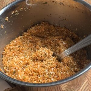 coarse spice powder in a steel bowl with a spoon, showing the texture of the ground peanuts and chana dal