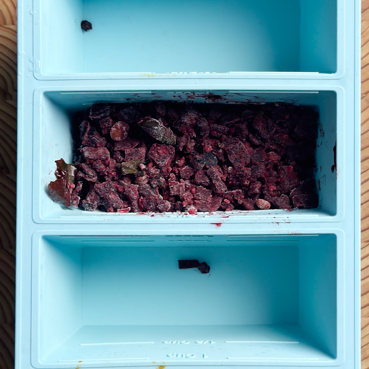 Frozen andhra beetroot fry in a blue Souper Cube tray, one compartment showing a solid frozen portion