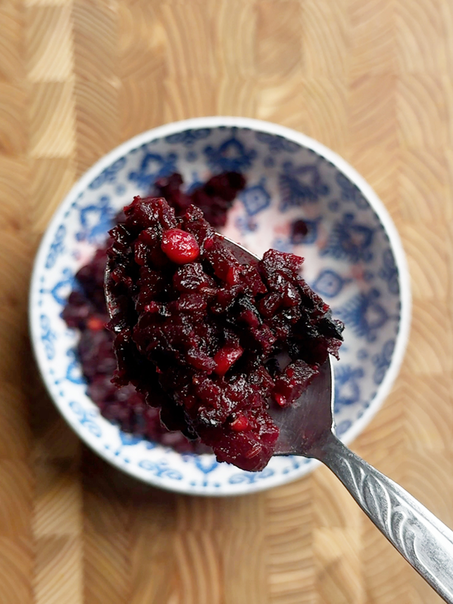 Reheated andhra beetroot fry on a spoon over a blue bowl, showing texture after reheating from frozen