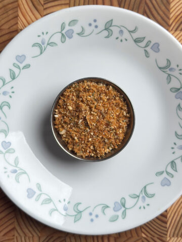 andhra spice powder served in a small steel bowl on a white decorative plate