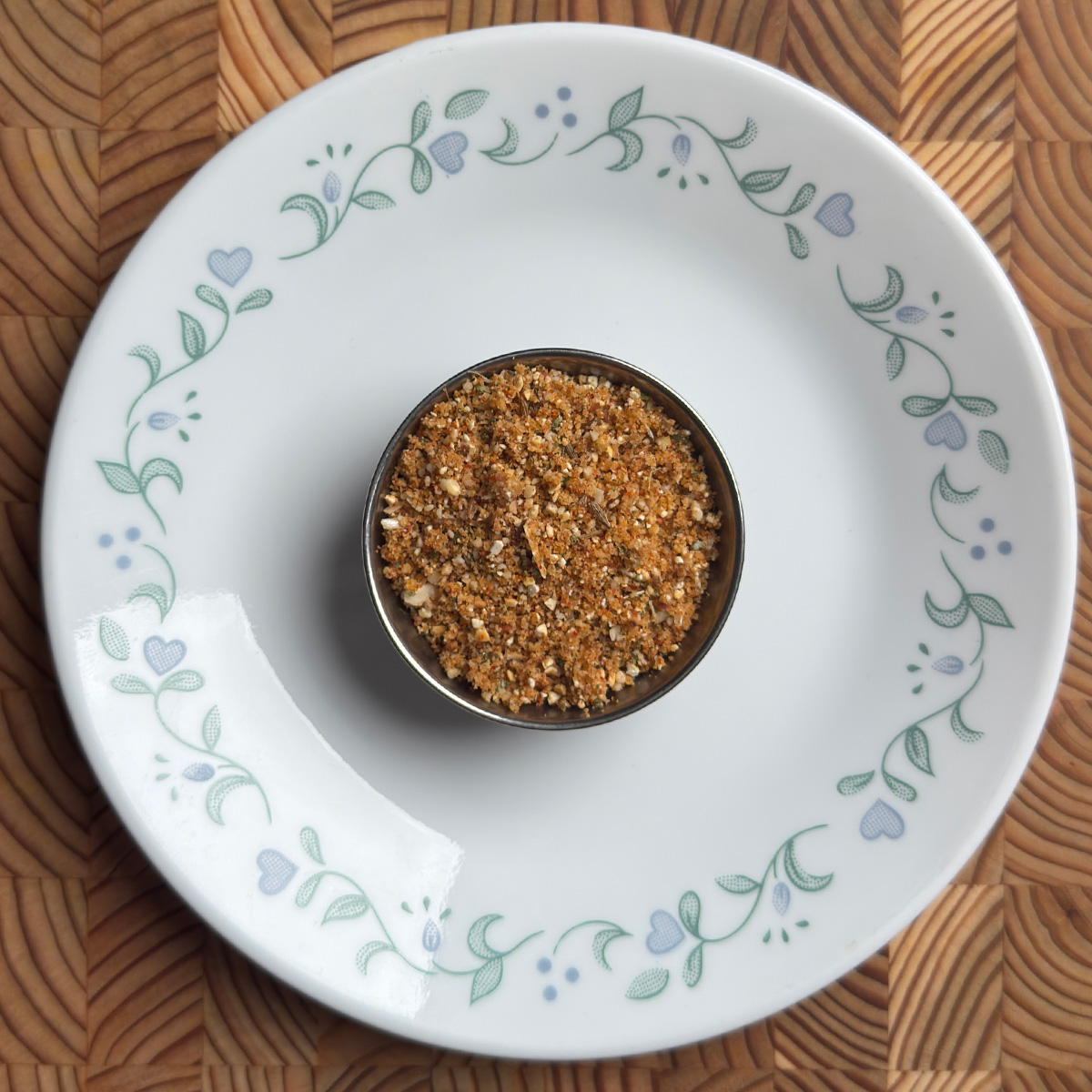 andhra spice powder served in a small steel bowl on a white decorative plate