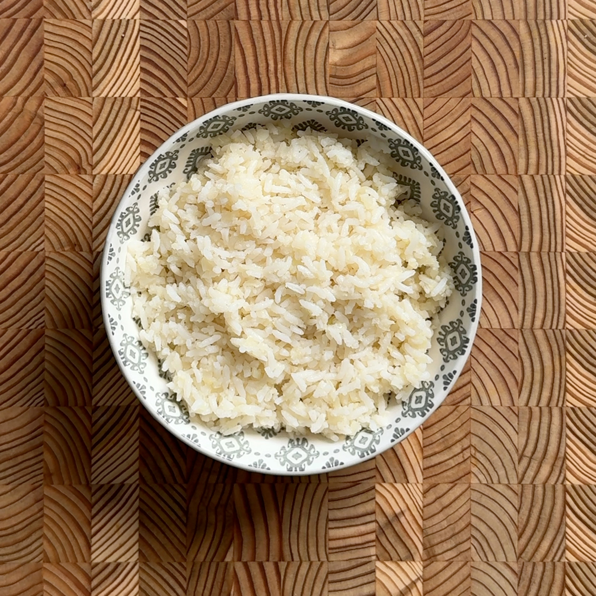 Overhead view of cooked rice and riced cauliflower blend in a patterned bowl