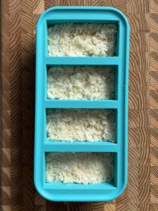 Cooked rice and cauliflower rice portioned into a silicone freezer tray for meal prep