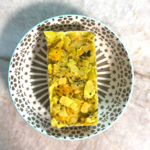 A single frozen block of paneer cabbage scramble set on a patterned plate.